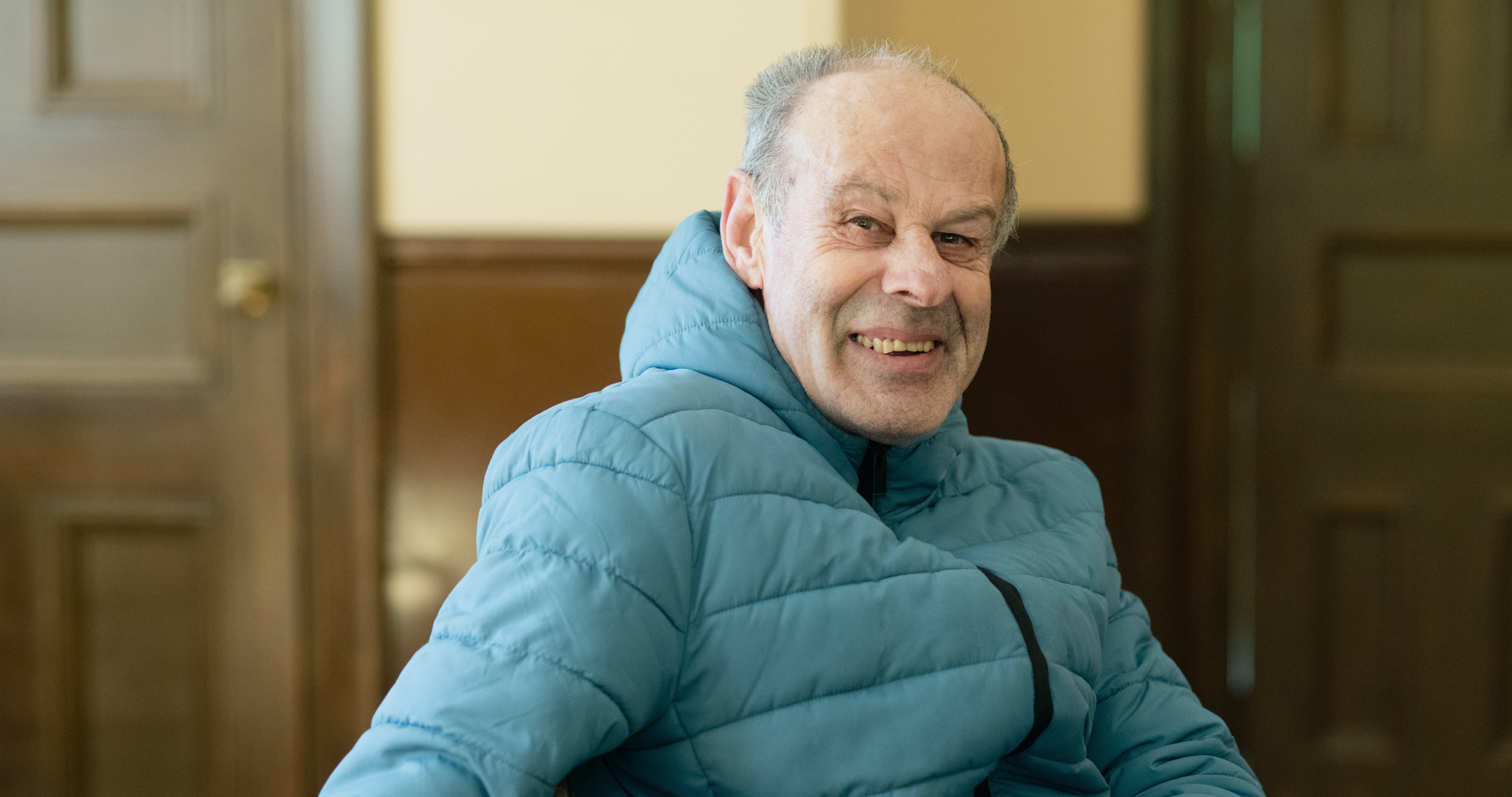 Man in blue jacket smiling at the camera